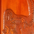 Dinosaur skeleton carving. Mahogany, light walnut stain.