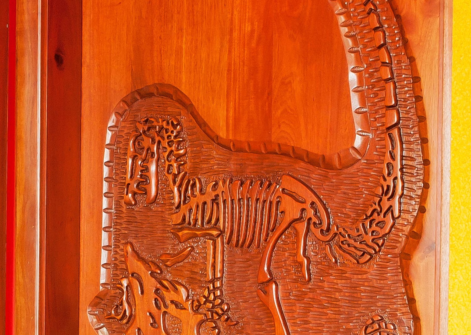 Dinosaur skeleton carving. Mahogany, light walnut stain.