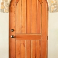 Full arch plank style mahogany door with wooden pegs