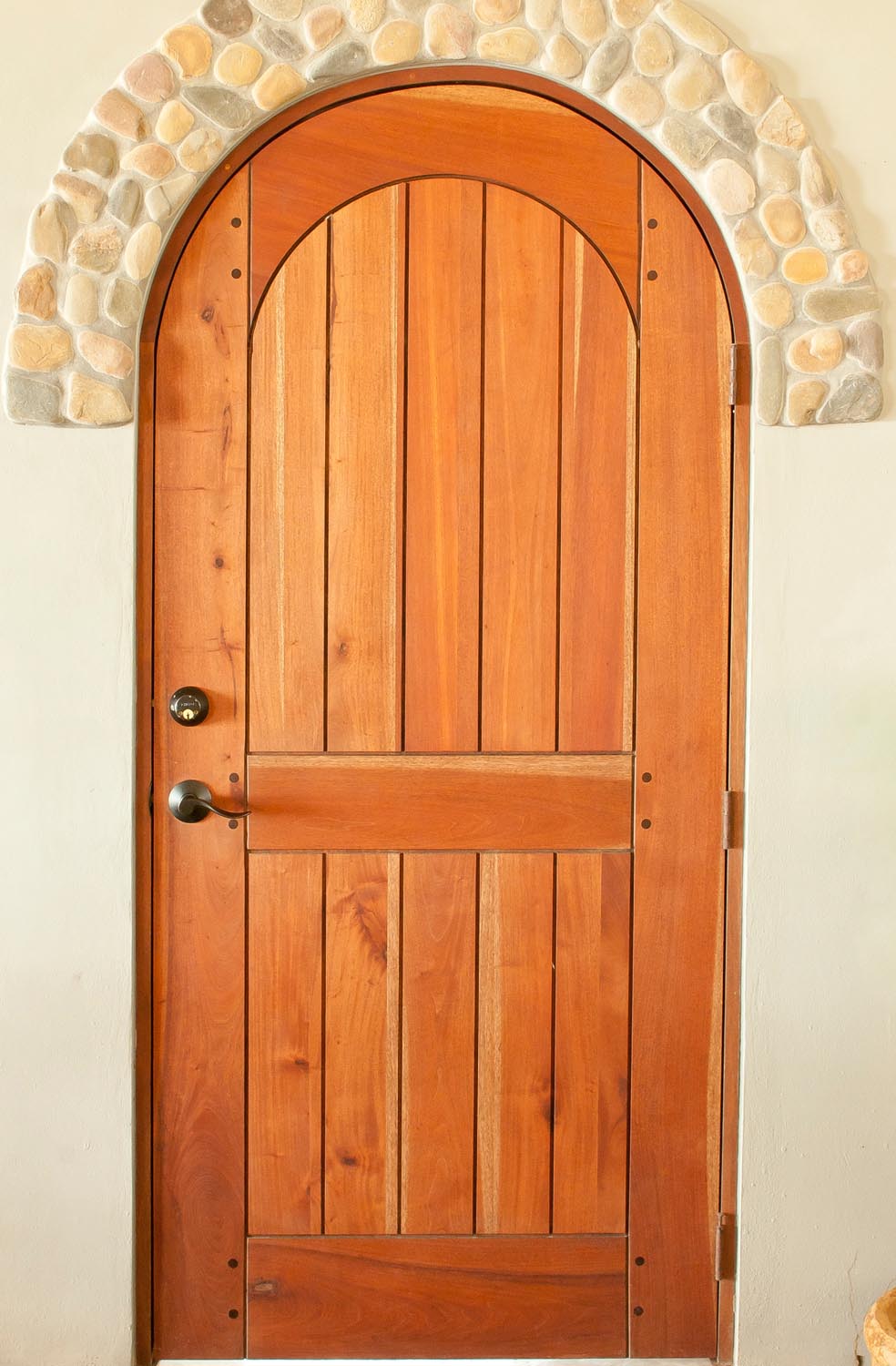 Full arch plank style mahogany door with wooden pegs