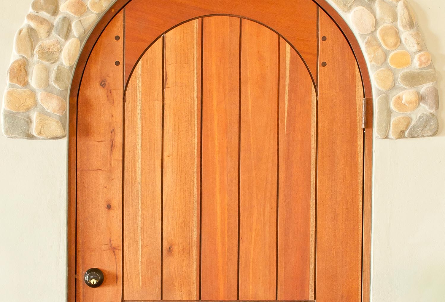 Full arch plank style mahogany door with wooden pegs
