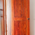 Figured mahogany, plank style, eyebrow arch panel top door.