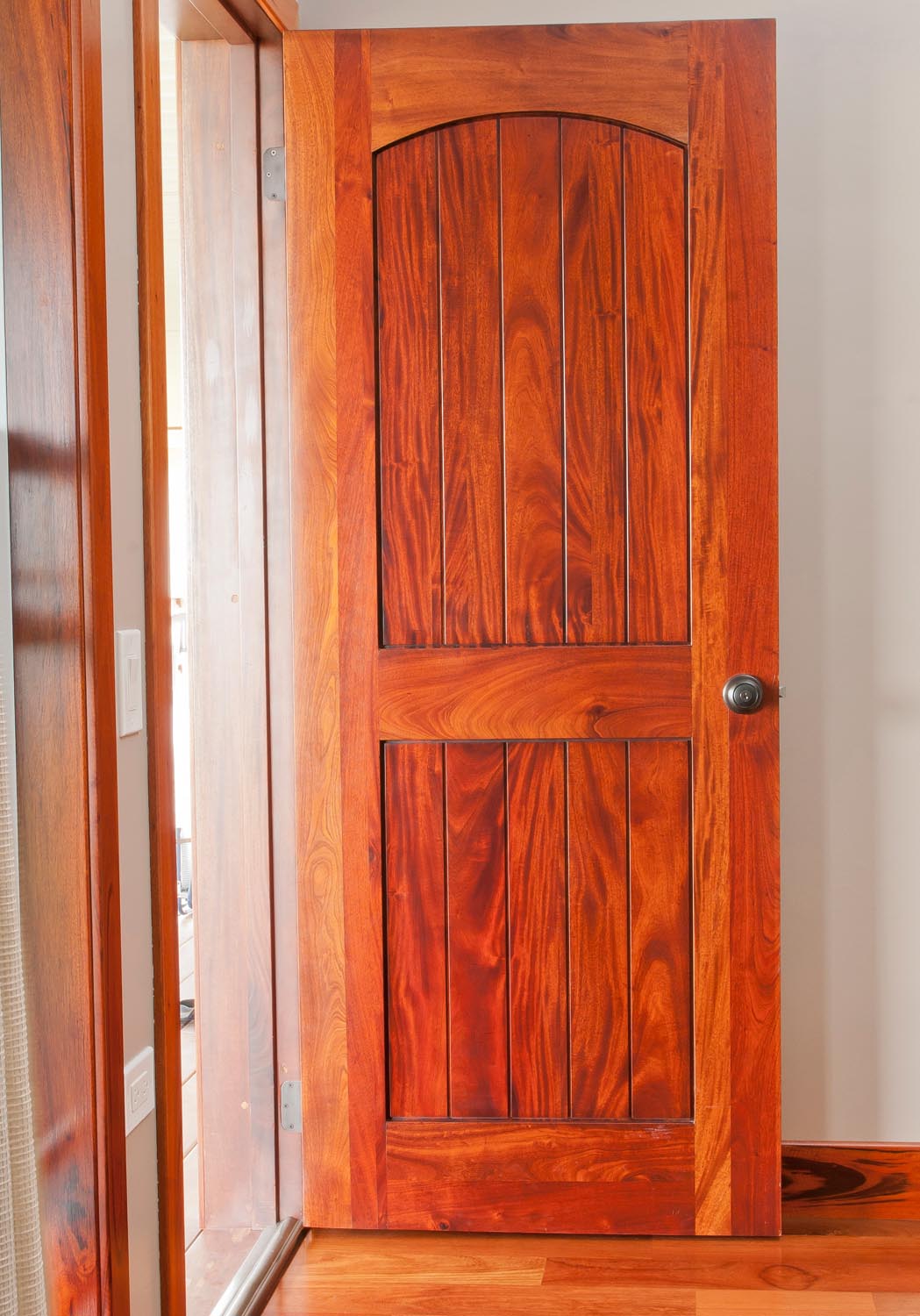 Figured mahogany, plank style, eyebrow arch panel top door.